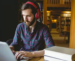 person wearing headphones using laptop